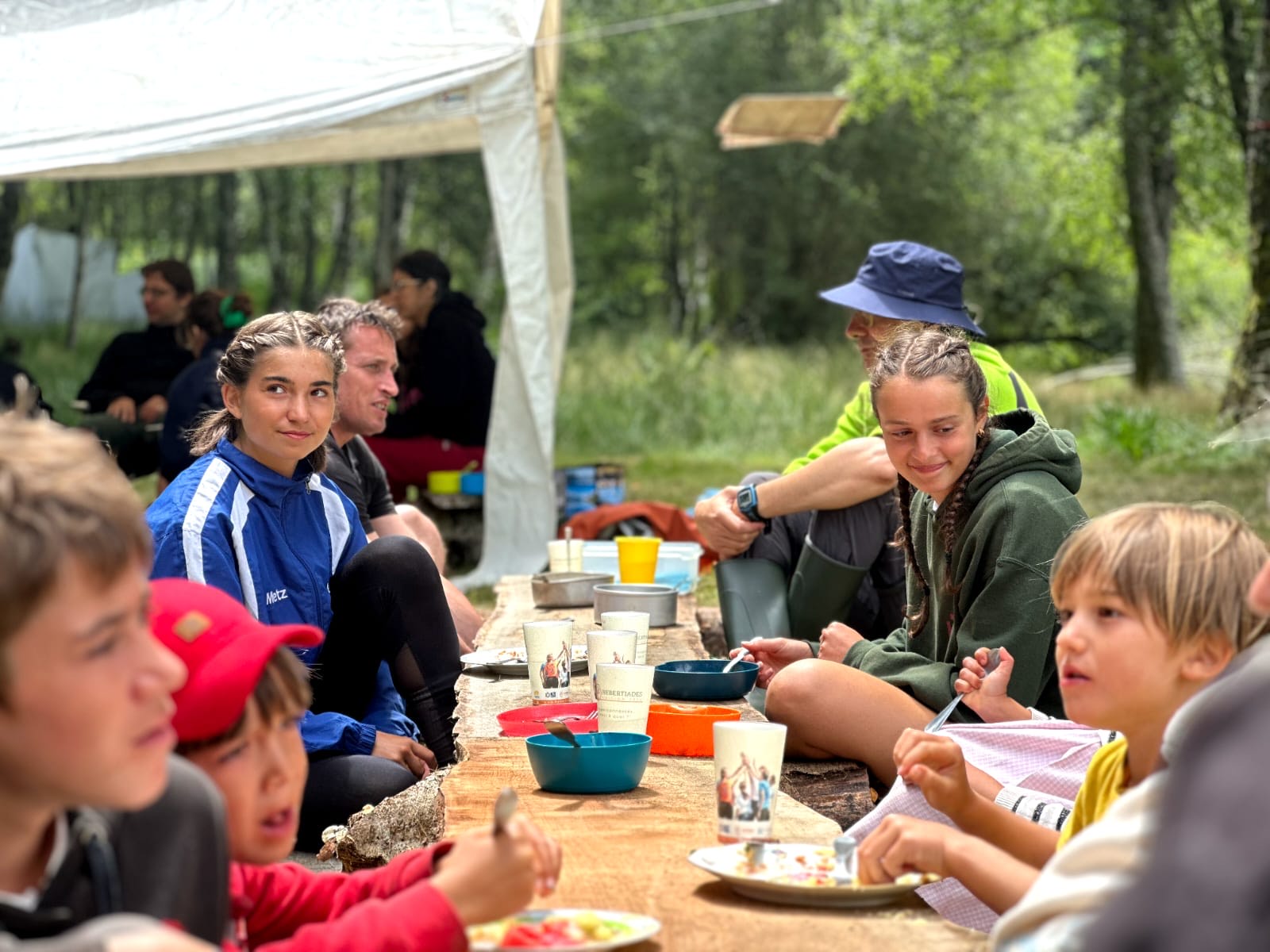 Repas convivial sous la tente pendant un camp en forêt