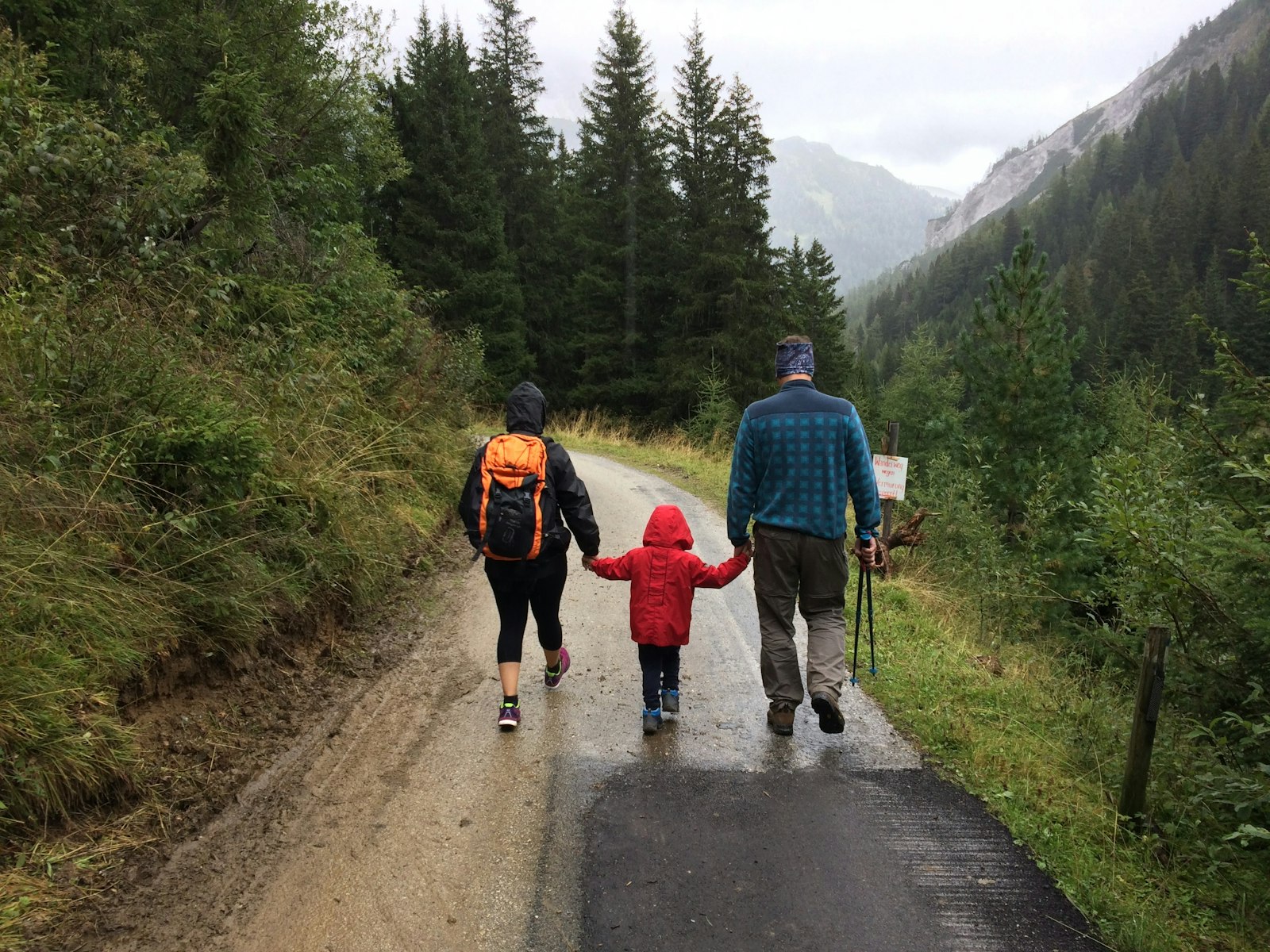 Famille marchant main dans la main sur un chemin de montagne